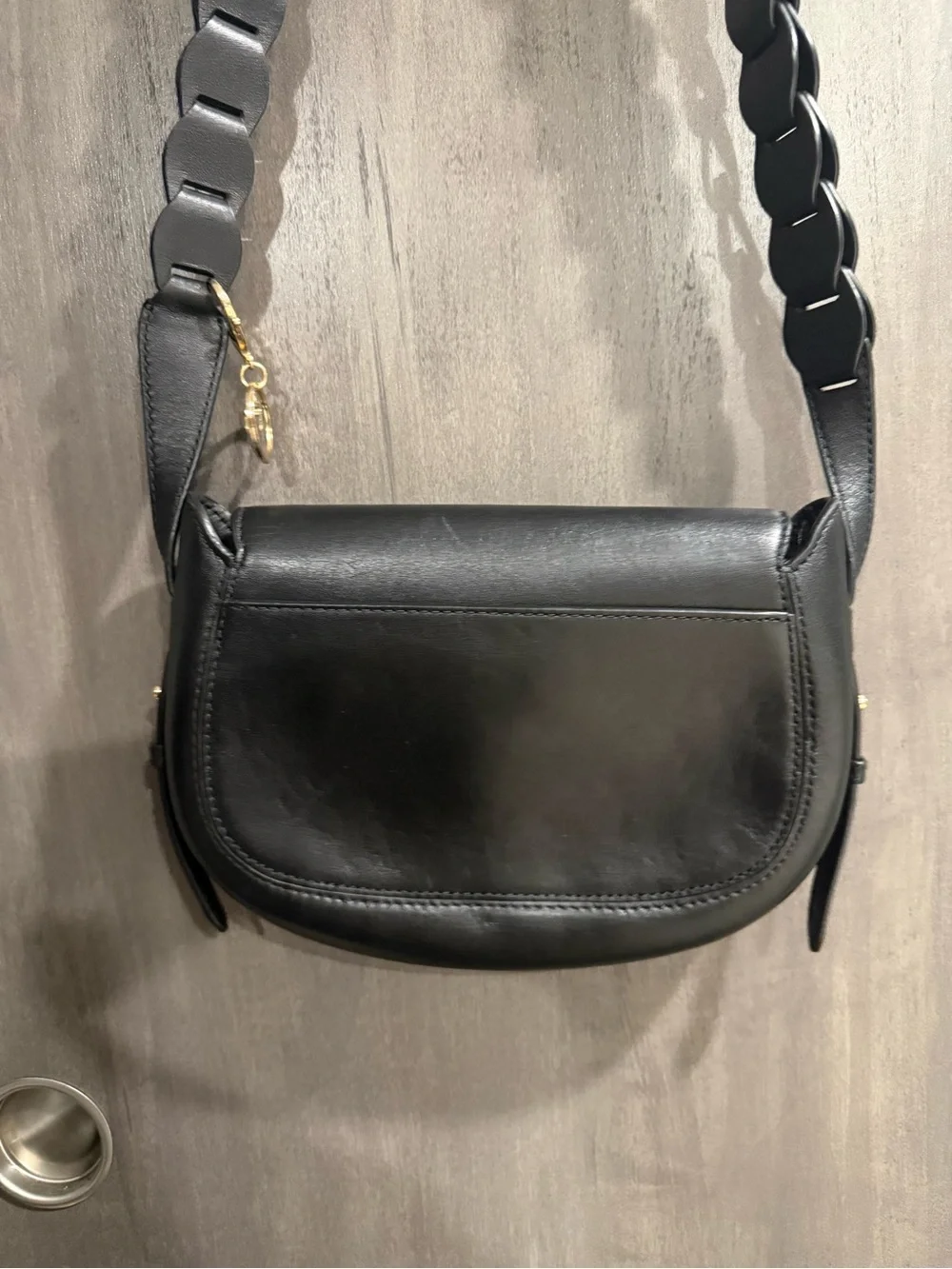 ⁠MICHAEL KORS Jolene black leather saddle bag with interlocking woven strap
